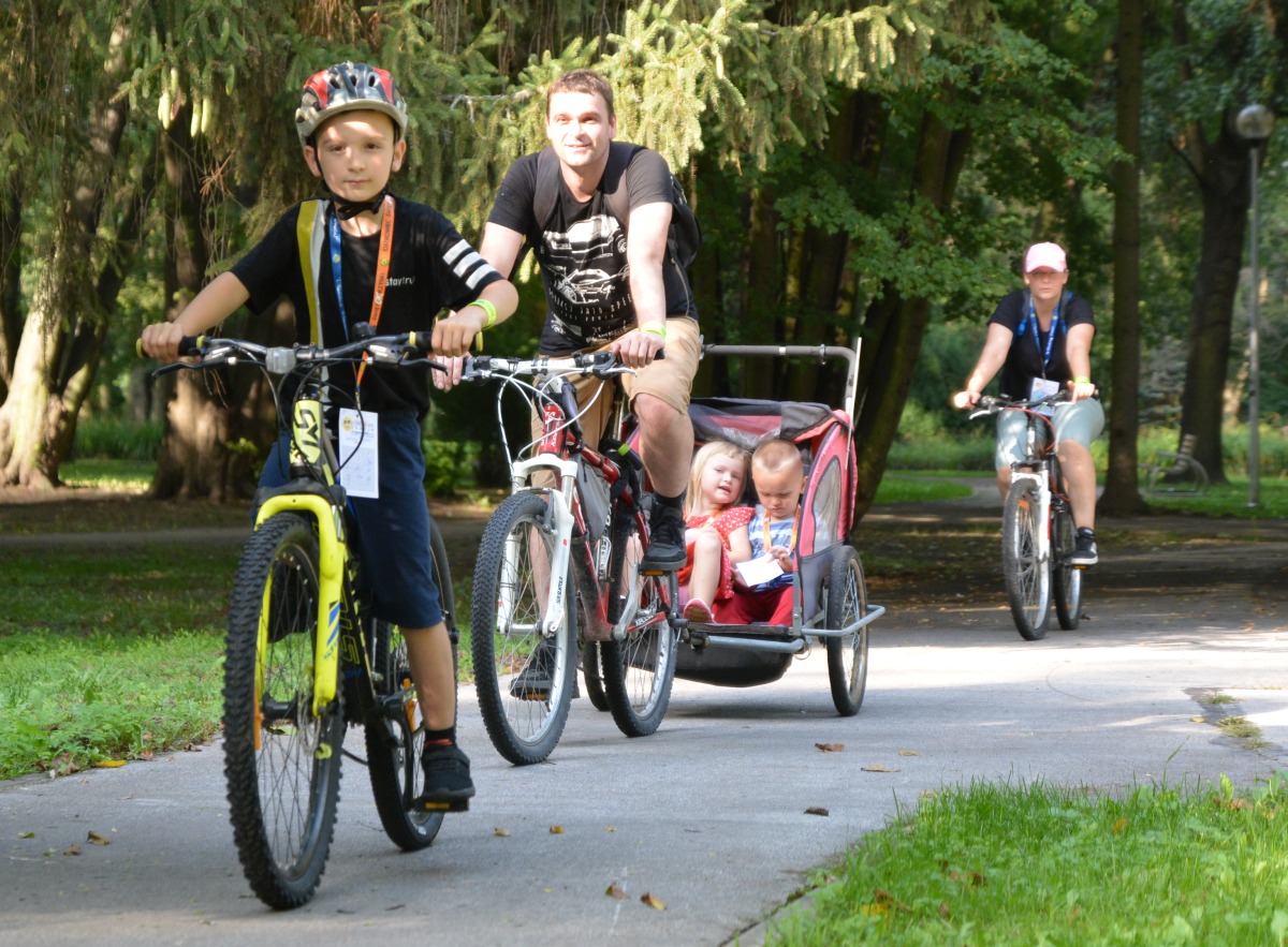 Rodzina na rowerach podczas terenowej gry w Parku Miejskim.